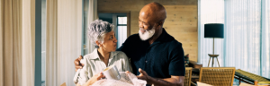 Generation X African-American Couple Unpacking Memories and Smiling in New Home During Retirement Transition